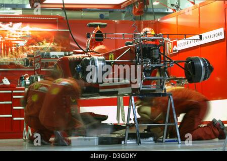 (Afp) - Travaux de mécanique sur une voiture de course Ferrari Ferrari à la cavité sur le nouveau Circuit International de Shanghai à Shanghai, Chine, le 24 septembre 2004. Banque D'Images