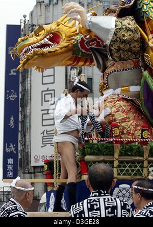 (Afp) - Des artisans dans des vêtements traditionnels mettent la dernière main à une statue ornée de fête qui a été mis en place pour célébrer la pose de la première pierre d'un nouveau centre commercial à Shanghai, Chine, 21 septembre 2004. Le Grand Prix de Formule 1 de Chine aura lieu sur la nouvelle piste de course pour la première fois à Shanghai le dimanche, 26 septembre 2004. Banque D'Images