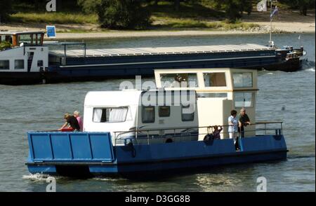 (Afp) - Le nouveau 'Camper' Aqua, un bateau pour les campeurs qui peut transporter une caravane, passe d'un cargo sur le Rhin près de Düsseldorf, Allemagne, 18 août 2004. Le bateau mesure 13,5 m de long et peut être pilotée par les vacanciers sans un permis de conduire spécial. Il offre un espace pour une caravane ainsi que d'installations sanitaires. À partir de 2005, le bateau peut être affrété. Banque D'Images