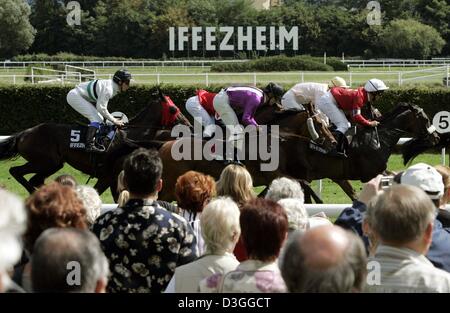 (Afp) - Un groupe de coureurs courses passé les spectateurs pendant la semaine du Festival 'Grand' à la piste de course à Iffezheim, Allemagne, 31 août 2004. Une des premières courses de chevaux en Allemagne les 6 jours jusqu'au 5 septembre 2004. Banque D'Images