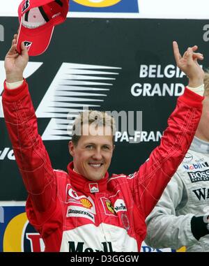 (Afp) - L'Allemand pilote de Formule Un Ferrari Michael Schumacher célèbre sur le podium après la formule un Grand Prix de Belgique à Spa, 29 août 2004. Michael Schumacher a terminé en deuxième place dans le Grand Prix, remportant un nombre sans précédent de septième titre de champion du monde en dépit de ne pas gagner pour seulement la deuxième fois en 14 courses cette saison. Banque D'Images