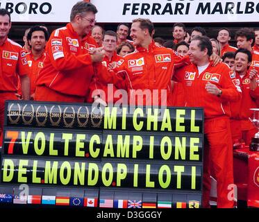 (Afp) - L'Allemand Ferrari pilote de Formule 1 Michael Schumacher (C) célèbre avec la tête de l'équipe Ferrari Jean Todt (R) et technicien en chef Ross Brawn après la formule un Grand Prix de Belgique à Spa, 29 août 2004. Michael Schumacher a terminé en deuxième place dans le Grand Prix, remportant un nombre sans précédent de septième titre de champion du monde en dépit de ne pas gagner pour seulement la deuxième fois Banque D'Images