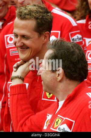 (Afp) - L'Allemand Ferrari pilote de Formule 1 Michael Schumacher (L) célèbre avec tête de Ferrari Jean Todt et toute son équipe après la formule un Grand Prix de Belgique à Spa, 29 août 2004. Schumacher a terminé en deuxième place dans le Grand Prix, remportant un nombre sans précédent de septième titre de champion du monde en dépit de ne pas gagner pour seulement la deuxième fois en 14 courses cette saison. Banque D'Images