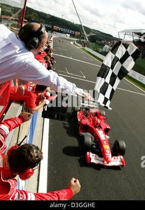 (Afp) - L'Allemand pilote de Formule Un Ferrari Michael Schumacher voit le drapeau à damier après la formule un Grand Prix de Belgique à Spa, 29 août 2004. Michael Schumacher a terminé en deuxième place dans le Grand Prix, remportant un nombre sans précédent de septième titre de champion du monde en dépit de ne pas gagner pour seulement la deuxième fois en 14 courses cette saison. Banque D'Images