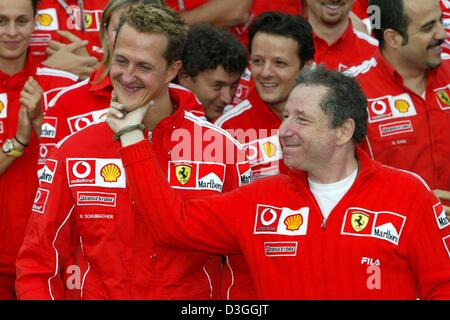 (Afp) - L'Allemand Ferrari pilote de Formule 1 Michael Schumacher (L) célèbre avec tête de Ferrari Jean Todt (R) et le reste de son équipe après la formule un Grand Prix de Belgique à Spa, 29 août 2004. Schumacher a terminé en deuxième place dans le Grand Prix, remportant un nombre sans précédent de septième titre de champion du monde en dépit de ne pas gagner pour seulement la deuxième fois en 14 courses cette saison. Banque D'Images