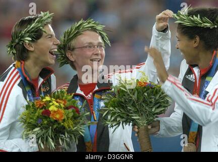 (Afp) - Joueurs de football allemand (fromL :) Ariane Hingst, Conny Pohlers et Navina Omilade célébrer sur le podium lors de la cérémonie de remise des médailles du tournoi de football féminin des Jeux Olympiques d'Athènes de 2004 au stade Karaiskaki, jeudi 26 août 2004. L'équipe américaine a remporté la médaille d'argent et l'Allemagne, le Brésil, la médaille de bronze. Banque D'Images