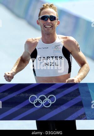 (Afp) - le néo-zélandais Hamish Carter sourire alors qu'il franchit la ligne d'arrivée pour gagner le triathlon olympique à Athènes, Grèce, le 26 août 2004. Banque D'Images