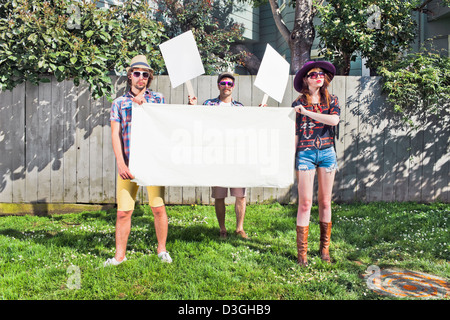 Les gens branchés et Beatniks - Trois hipsters démontrant tout en maintenant des plaques vierges, signes, et la bannière Banque D'Images