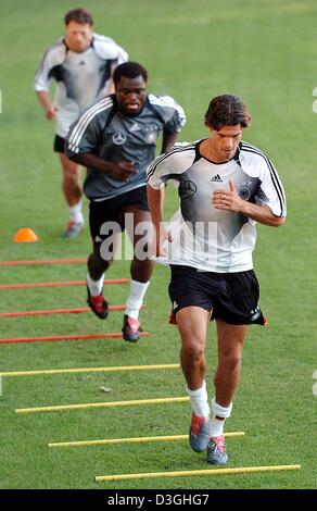 (Afp) - Le milieu de terrain allemand et nouveau capitaine de l'équipe nationale allemande de soocer Michael Ballack (avant) et son coéquipier Gerald Asamoah (C) mener des exercices de sprint durant leur formation à Vienne, Autriche, 17 août 2004. Ballack réussit gardien Oliver Kahn en tant que capitaine d'équipe. L'équipe allemande a préparé pour le match amical contre l'Autriche mercredi, 18 août 2004. Banque D'Images