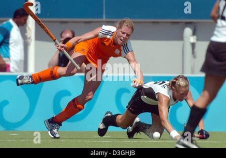 (Afp) - (de G :) joueur néerlandais Lieve van Kessel et Fanny Rinne de Allemagne tombent au sol au cours de la ronde préliminaire de la femme match de hockey lors des Jeux Olympiques de 2004 à Athènes, mercredi 18 août 2004. Banque D'Images