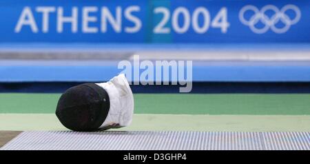 (Afp) - un masque d'escrime se trouve sur le sol devant le logo des Jeux Olympiques de 2004 au cours de la compétition à l'épée l'Helliniko Olympic Hall à Athènes, Grèce 17 août 2004. Banque D'Images