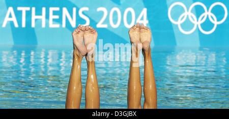 (Afp) - Les pieds de natation synchronisée stick hors de l'eau en face d'un logo olympique lors d'une session pratique à la Piscine Olympique OAKA Synchro aquatiques à Athènes, Grèce, 09 août 2004. Les Jeux Olympiques de 2004 sera lancé avec la cérémonie d'ouverture le 13 août. Banque D'Images