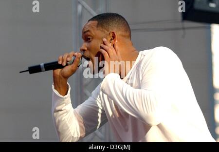 (Afp) - L'acteur américain Will Smith joue sur la scène lors d'un court concert rap pour ses fans avant la première Allemande de son nouveau film "I, Robot" à Berlin, 02 août 2004. Banque D'Images