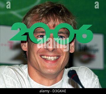 (Dpa) - Juergen Klinsmann, ancien attaquant et capitaine de l'équipe de l'équipe nationale de football allemande, sourire alors qu'il pose avec une paire de verres de papier qui annoncent le Championnat du Monde de Football 2006 au cours d'une conférence de presse à Francfort-sur-Main, Allemagne, 29 mai 1998. Plusieurs journaux ont rapporté le 22 juillet 2004, que Klinsmann est de réussir Rudi Voeller comme chef d'équipe de l'allemand Banque D'Images