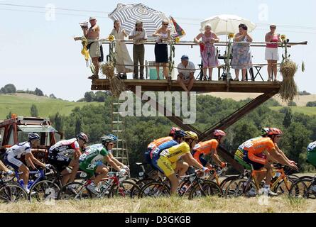 (Afp) - Fans regarder les cyclistes passent d'un stand de fortune sur une rampe de levage lors de la 12e étape du Tour de France cycliste de Castelsarrasin à La Mongie, France, le 16 juillet 2004. Les 197,5 km longue étape a été la première étape dans les Pyrénées. Banque D'Images