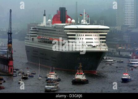 (Afp) - Le plus grand et le plus cher navire de croisière, le Queen Mary 2, entre dans le port de Hambourg, Allemagne, 19 juillet 2004. Des dizaines de milliers de spectateurs curieux vis le grand paquebot la tête de la rivière dans le quartier du port avec plusieurs petits bateaux suivant le navire. Le Queen Mary 2 va rester au Grasbrook- Borne pour un jour où un festival aura lieu Banque D'Images