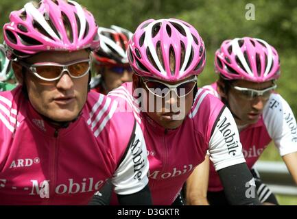 (Afp) - le cycliste allemand Jan Ullrich (C) de l'équipe T-Mobile au milieu des cycles de ses coéquipiers, Matthias Kessler (L) de l'Allemagne et Giuseppe Guerini de l'Italie, au cours de la neuvième étape du Tour de France cycliste en France, 13 juillet 2004. Le 160.5km longue étape a pris les cyclistes de Saint-Léonard-de-Noblat à Gueret. Banque D'Images