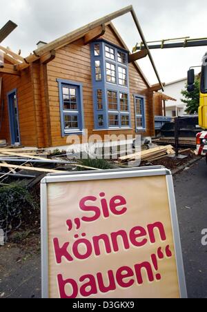 (Afp) - 'Sie koennen bauen' (vous pouvez construit) dit qu'un signe en face d'un modèle de maison qui est en construction à l 'Eigenheim und Garten' (Maison et jardin) juste à Bad Vilbel, Allemagne, 14 juillet 2004. Le gouvernement allemand a annoncé qu'elle a pour objectif de supprimer totalement les subventions actuelles pour les constructeurs privés et d'utiliser l'argent économisé pour un programme qui récompense les entreprises innovantes Banque D'Images