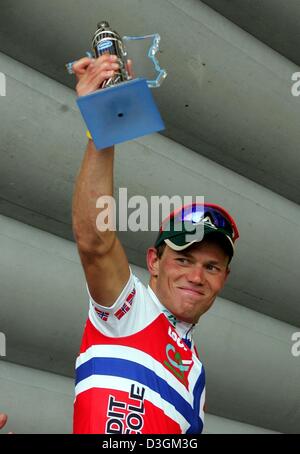 (Afp) - coureur norvégien Thor Hushovd de l'équipe Credit Agricole sourit comme il détient le trophée dans sa main après avoir remporté la huitième étape du Tour de France à Quimper, France, le 11 juillet 2004. La scène couvre une distance de 168 km de Lamballe à Quimper. Banque D'Images