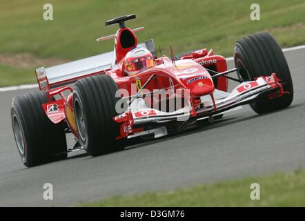 (Dpa) pilote de Formule 1 brésilien Rubens Barrichello de Ferrari conduit sa voiture de course sur le tarmac de l'racing circuit au cours de la première formation à Silverstone, UK, vendredi, 09 juillet 2004. Le Grand Prix de Grande-Bretagne commence le dimanche 11 juillet 2004. Banque D'Images