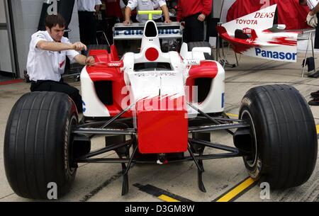 (Afp) - Un mécanicien travaille sur une voiture de course de Toyota dans la voie des stands du circuit de Silverstone race course à Silverstone, en Grande-Bretagne, le jeudi 8 juillet 2004. Ralf Schumacher se joindra à la Cologne, Allemagne équipe basée, dans la prochaine saison de course. Le frère du champion de Formule 1 Michael Schumacher, qui est actuellement sous contrat avec BMW-Williams et soins infirmiers est une blessure causée par un accident de la Indiana Banque D'Images