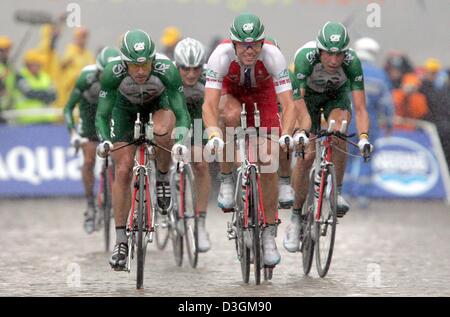 (Afp) - L'équipe Crédit Agricole, dirigé par cycliste norvégien Thor Hushovd (C), des manèges pendant le long 64,5 km quatrième étape du Tour de France de Cambrai à Arras, France, 7 juillet 2004. Les fortes pluies tout au long de l'étape a causé beaucoup de problèmes et de défauts. L'équipe a terminé en 12e place. Banque D'Images