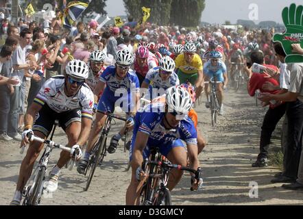 (Afp) - le cycliste italien Mario Cipollini (L) de l'équipe Domina Vacanze et rider néerlandais Servais Knaven en Hollande (R) de l'équipe Quick Step-Davitamon un groupe de tête qui passe au-dessus de cobblestone au cours de la troisième étape du Tour de France près de Waterloo, Belgique, le 6 juillet 2004. La troisième et 210km longue étape du 91ème Tour de France cycliste a pris les cyclistes de Waterloo à Wasquehal, France. Banque D'Images