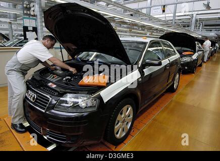 (Afp) - Un employé a l'air sous le capot d'une nouvelle Audi A3 à l'usine d'Audi à Ingolstadt, Allemagne, le 15 juin 2004. Banque D'Images