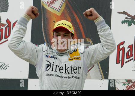 (Afp) - Colombie Britannique pilote Mercedes DTM Gary Paffett cheers au cours de la cérémonie de remise des prix à Nuremberg, Allemagne, 27 juin 2004. 22-year-old Paffett a réussi à s'affirmer dans la cinquième course du championnat allemand DTM (voitures de maîtres) et a gagné sur les 2 300 km de long track après 72 rond avec un temps d'1.00.52,341 heures. Banque D'Images