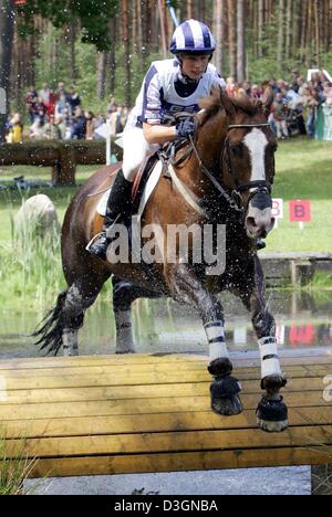 (Afp) - La rider Zara Phillips, petite-fille de la reine britannique et la fille de la princesse Anne, supprime un obstacle sur son Springleaze Marcaroo cheval au cours de l'événement au cross-country de la Coupe du Monde de CIC à Luhmuehlen, Allemagne, 19 juin 2004. Après le dressage et le Cross Country events, Phillips était en deuxième place. À la fin, elle a terminé septième. Banque D'Images