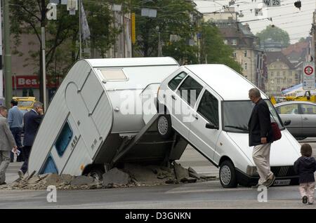 (Afp) - Une installation artistique d'artistes Elmgreen & Dragset intitulé 'Short cut' capture l'intérêt des piétons en passant en face de la foire d'art "L'Art" à Bâle, en Suisse, le 15 juin 2004. Le mercredi 16 juin 2004 l 'Art', qui dure jusqu'au 21 juin, sera ouvert pour la 35e fois. Galeries 270 présentera des œuvres de plus de 1 500 artistes contemporains au 'ART', qui est Banque D'Images