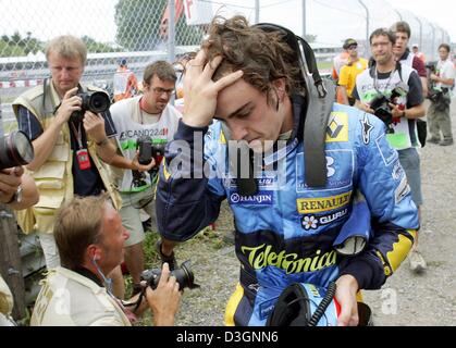 (Afp) - pilote de Formule 1 espagnol Fernando Alonso (Renault) retourne à la fosse à pied après une panne moteur lors du Grand Prix du Canada à Montréal, le 13 juin 2004. Banque D'Images