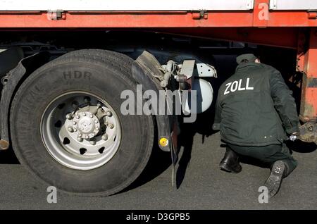 (Afp) - Un contrôle de la douane préposé vérifie la face inférieure d'un tracteur-remorque russe à la frontière germano-polonaise sur l'autoroute près de Francfort-sur-Oder, Allemagne de l'Est, 3 mars 2004. En ce moment 1 400 agents de contrôle des douanes sont en service à la frontière germano-polonaise de l'état allemand de Brandebourg. Les contrôles douaniers sera aboli à compter du 1 mai 2004, lorsque la Pologne se joint à la Banque D'Images