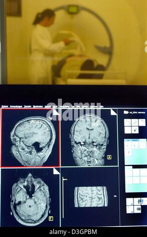 (Afp) - Un employé (contexte) est prêt pour une IRM à la recherche groupe 'Magnétique résonance (MR) la recherche en neurologie et en psychiatrie" à la clinique universitaire à Goettingen, Allemagne, 20 janvier 2004. En premier plan la section photos d'un cerveau sont visibles sur un écran. Le roman irm technique aide à trouver de nouvelles connaissances sur les maladies neurologiques et psychiatriques Banque D'Images