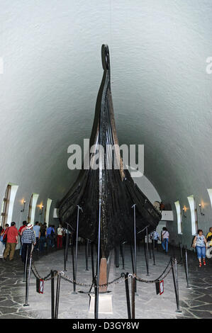 Les touristes à pied autour du navire Oseberg, un bateau viking découvert dans un grand tumulus funéraire près de Tønsberg, Norvège Banque D'Images