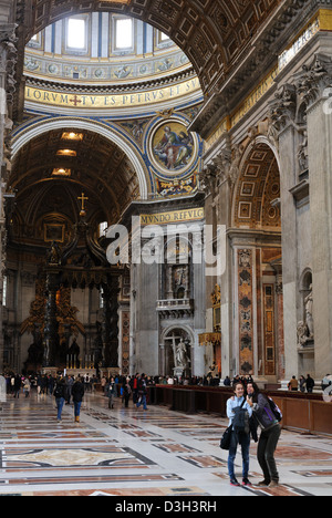 Des touristes posent pour une photo à l'intérieur de St Pierre de Rome. Banque D'Images