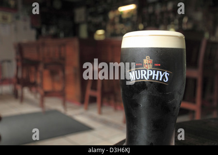 Une pinte de Murphy's Irish Stout repose sur une table dans un pub à Union Hall, West County Cork, République d'Irlande. Banque D'Images