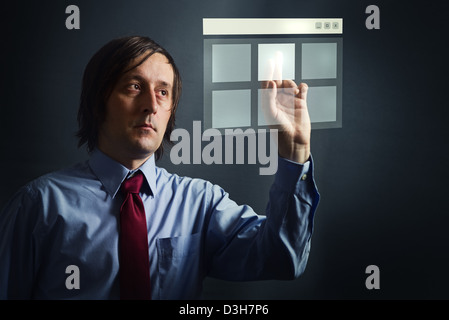 Woman in blue shirt appuyant sur un écran tactile interface bouton numérique Banque D'Images