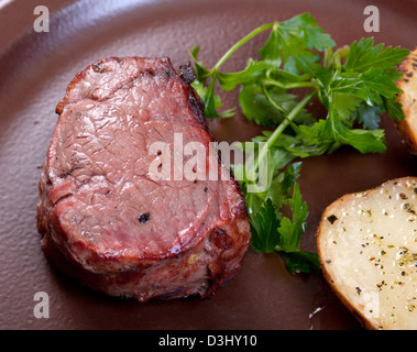 Boeuf grillé sur plaque blanche avec salade de pommes de terre et les tomates .faible profondeur de champ. Banque D'Images