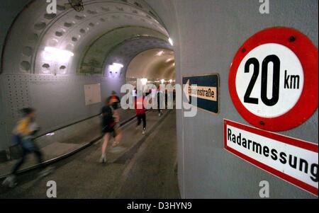 (Afp) - Un champ de coureurs passe devant un panneau qui dit "20 km, lectures radar' dans le tunnel Elb lors d'un marathon à Hambourg, Allemagne, 25 janvier 2004. Près de 250 coureurs ont participé au marathon à travers le tunnel. Afin de couvrir la distance d'un marathon, les coureurs ont à exécuter 48 fois à travers les deux tubes. Banque D'Images