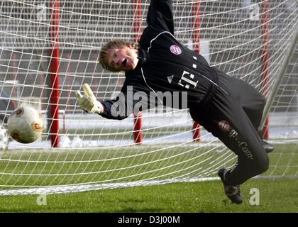 (Afp) - le gardien du Bayern Munich Oliver Kahn plonge pour la balle au cours d'une session pratique du club de football allemand FC Bayern Munich à Munich, Allemagne, 22 janvier 2004. Kahn tout juste rentré d'un voyage en Asie où il assister à des rendez-vous de la publicité. Banque D'Images