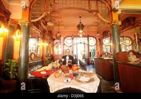 (Afp) - Un garçon decants une bouteille de vin au café Majestic, l'un des plus vieux cafés traditionnels à Porto, Portugal, le 7 avril 2003. Porto est un des lieux qui sera l'hôte du championnat d'Europe de football du 12 juin au 4 juillet au Portugal. Banque D'Images