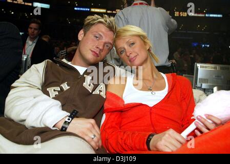 (Afp) - Le milliardaire américain héritier Paris Hilton et son petit ami Nick Carter, ancien chanteur des Backstreet Boys, sourire au cours de la NBA All-Star match de basket-ball à Los Angeles, Californie, USA, le 15 février 2004. Banque D'Images