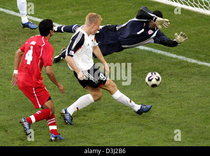 (Afp) - joueur de football allemand Mike Hanke (C) marque le troisième but allemand contre le gardien tunisien Ali Boumnijel, tandis que la Tunisie Wissem Abdi pendant le groupe d'un match de la Coupe des Confédérations Tunisie tournoi contre l'Allemagne à Cologne, Allemagne, 18 juin 2005. À gauche s'Wissem Abdi (TUN). L'Allemagne a gagné le match par un score de 3-0. Banque D'Images