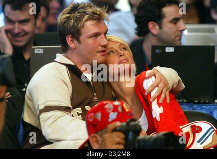 (Afp) - Le milliardaire américain héritier Paris Hilton et son petit ami Nick Carter, ancien chanteur des Backstreet Boys, s'embrassent comme ils regardent le à Los Angeles, Californie, USA, le 15 février 2004. Banque D'Images