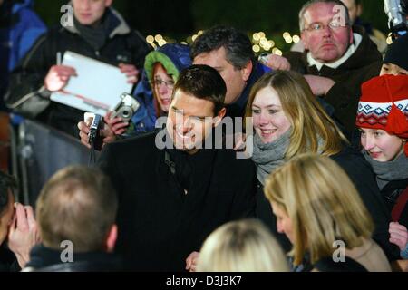 (Afp) - Hollywood star Tom Cruise (C) est photographié patiemment avec les fans de l'avant de la première européenne de son film "Dernier Samouraï" au Cinestar cinema à Berlin, 5 janvier 2004. Dans le film, qui a été annoncé comme un candidat à l'Oscar, Cruise joue un ancien combattant de la guerre civile américaine qui est embauché pour former l'Armée impériale japonaise, mais il est capturé par les samouraïs et finalement jo Banque D'Images