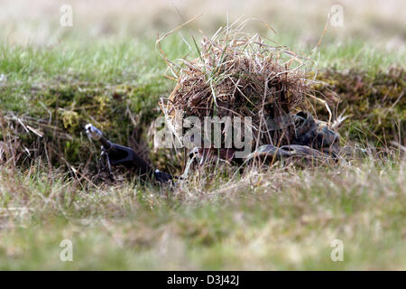 (Afp) - Le fichier photo, datée du 14 avril 2005, montre un conscrit de la division d'infanterie de la Bundeswehr, une tenue de camouflage, enlever le couvercle sur le sol avec son fusil G36 à un exercice sur le terrain dans le cadre de sa formation militaire de base à la caserne en Knuell Schwarzenborn, Allemagne, 14 avril 2005. Banque D'Images