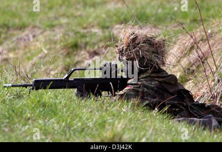 (Afp) - Le fichier photo, datée du 14 avril 2005, montre un conscrit de la division d'infanterie de la Bundeswehr, une tenue de camouflage, se coucher sur le sol et visez avec son fusil G36 à un exercice sur le terrain dans le cadre de sa formation militaire de base à la caserne en Knuell Schwarzenborn, Allemagne, 14 avril 2005. Banque D'Images