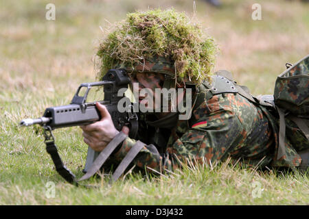 (Afp) - Le fichier photo, datée du 14 avril 2005, montre un conscrit de la division d'infanterie de la Bundeswehr, une tenue de camouflage, se coucher sur le sol et visez avec son fusil G36 à un exercice sur le terrain dans le cadre de sa formation militaire de base à la caserne en Knuell Schwarzenborn, Allemagne, 14 avril 2005. Banque D'Images