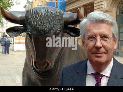 (Afp) - MTU Aero Engines président Udo Stark (R) se tient juste en face de la sculpture de Bull en face de la bourse de Francfort, Allemagne, lundi 06 juin 2005. La MTU en bourse a commencé avec succès. Le premier cours a été comptabilisées avec 21,89 euros et s'installe avec 21,78 euros après une heure dans le Xetra-index le commerce. Banque D'Images